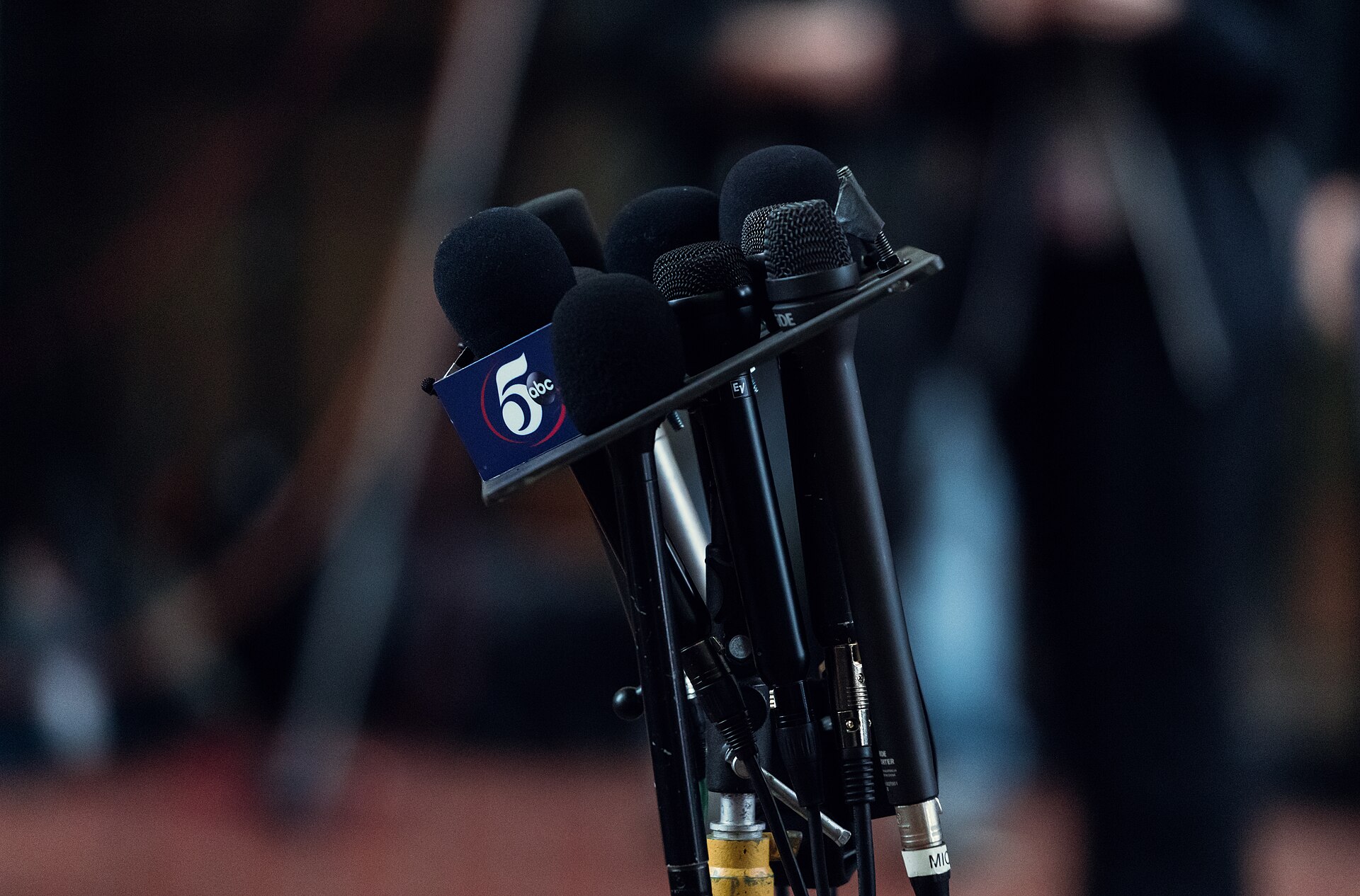 Plusieurs microphones de médias installés devant un pupitre de conférence de presse, photographie d'illustration