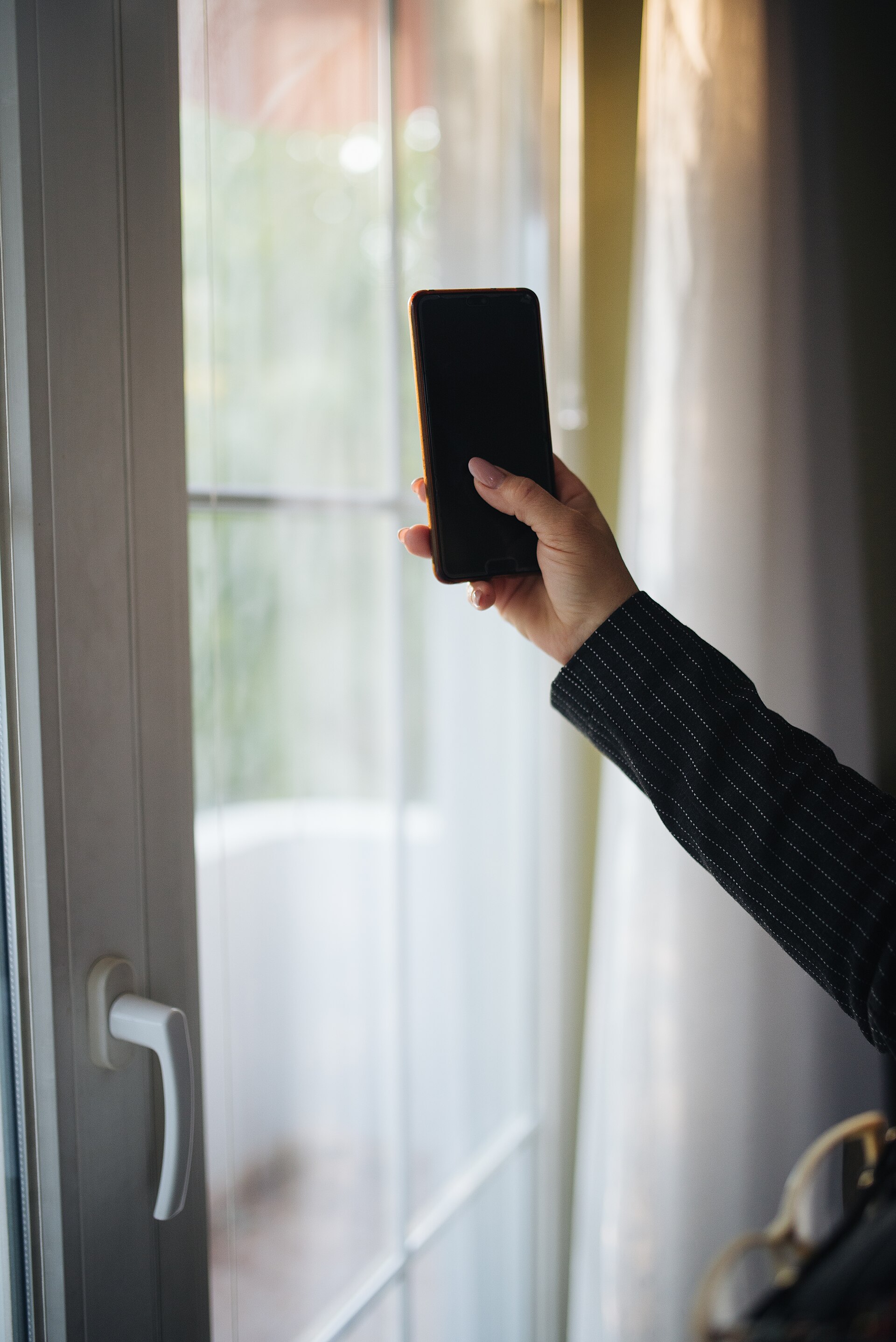Personne tenant un téléphone, photographie d'illustration sans écran de l'application ameli