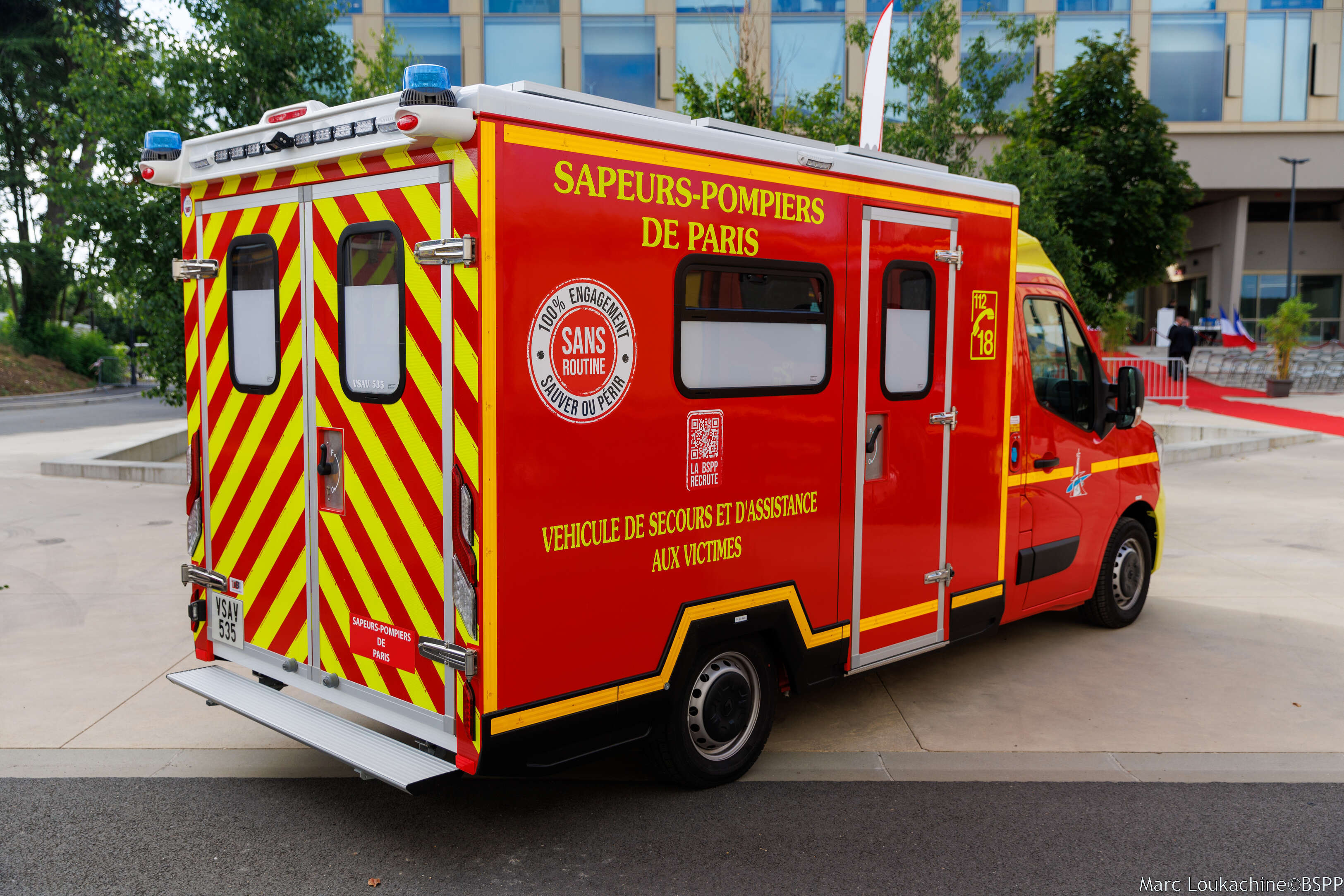 Véhicule de secours rouge des sapeurs-pompiers de Paris stationné devant un bâtiment